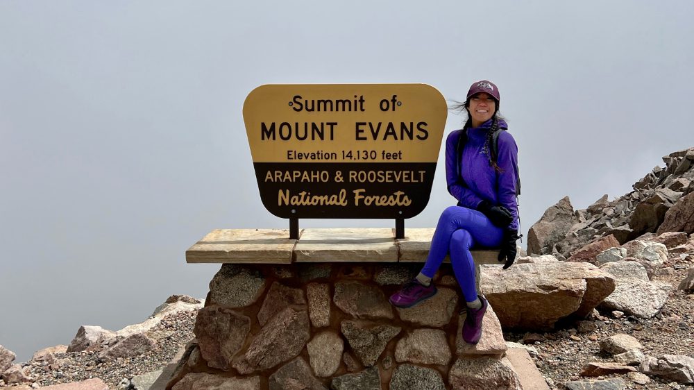 asian girl in purple at mt evans sign colorado