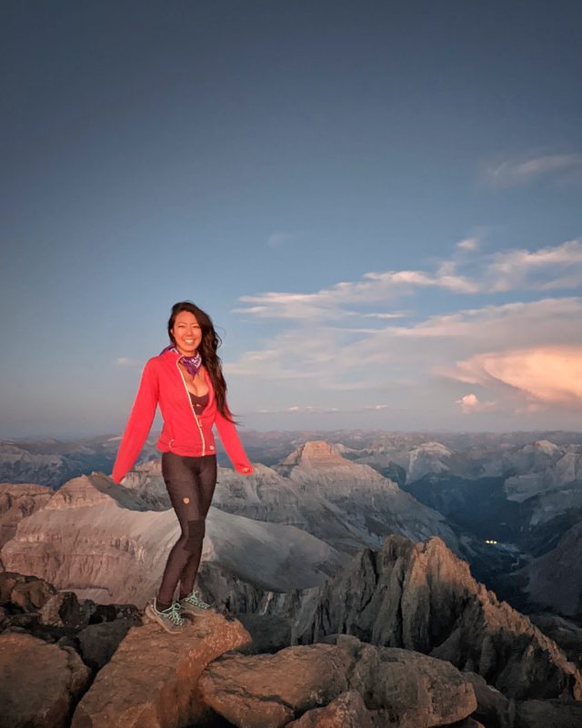 asian girl in red jacket and black leggings fjallraven abisko on colorado summit sneffels
