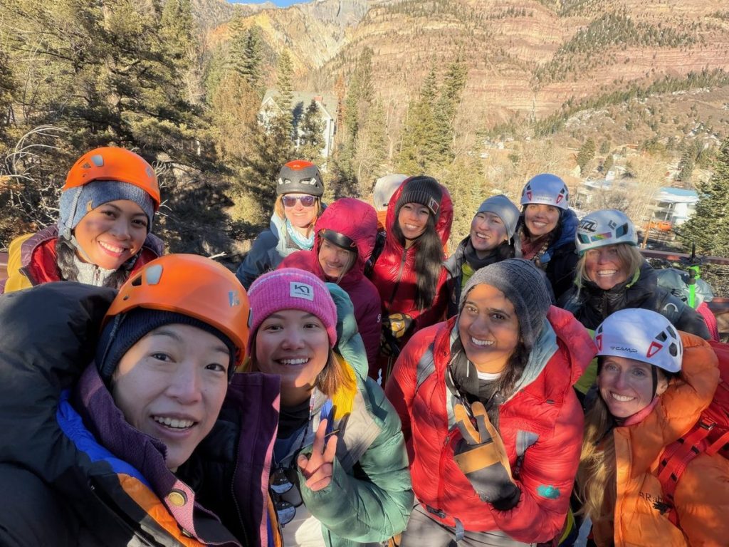 Smiling women wearing helmets together at Ouray Ice Park in 2026