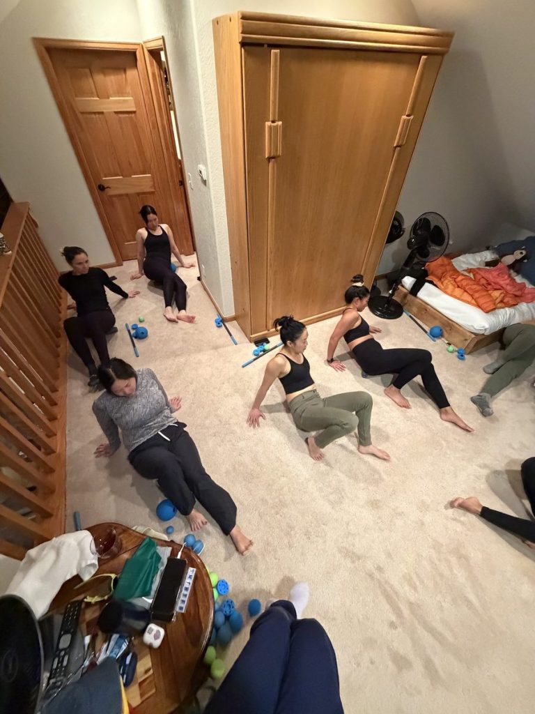 Women practicing RAD Roller self-massage and recovery together at the house