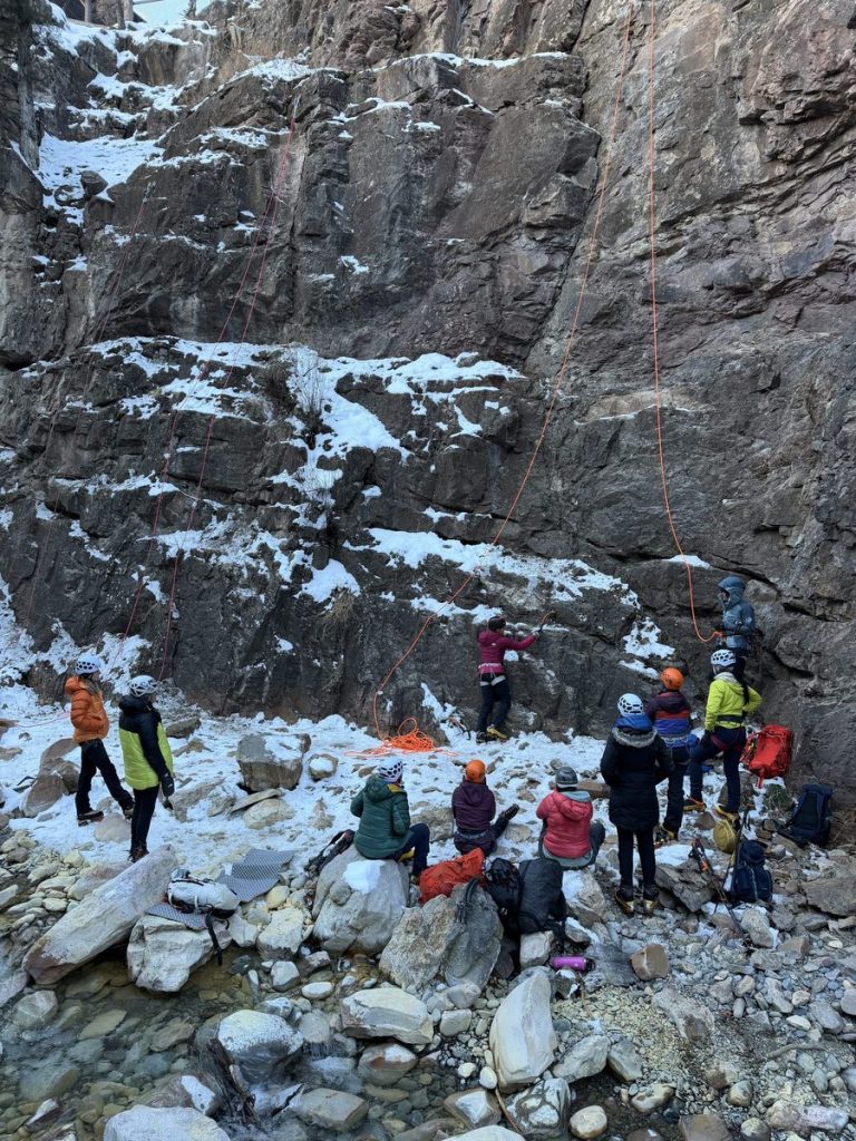 Women learning together at the base of frozen waterfalls in Ouray Ice Park